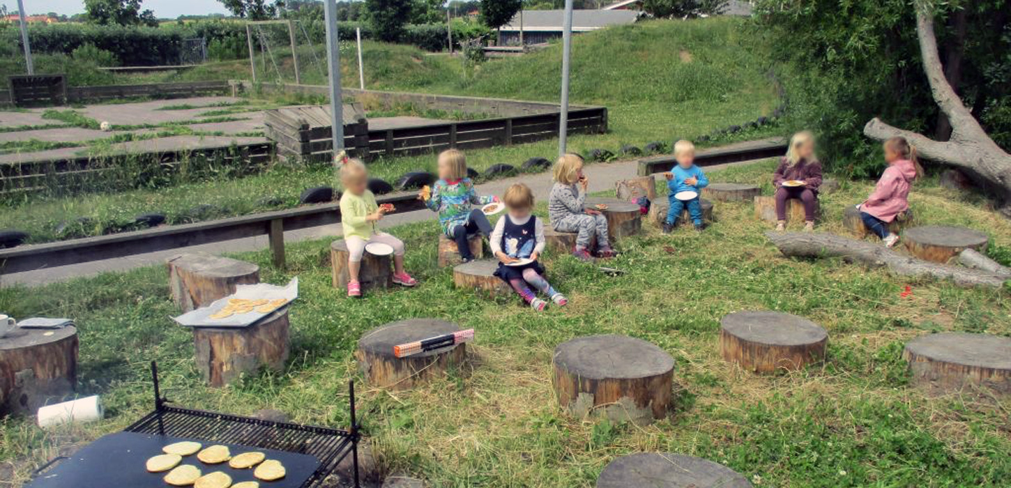 Børn spiser klatkager bagt over åben ild