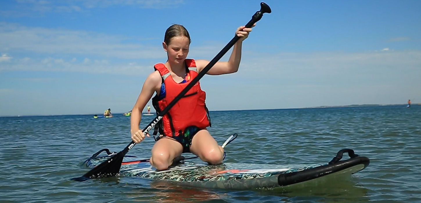 Pige siddende på SUP board ved Bagenkop
