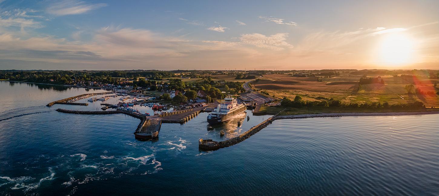 Aerial view of a ferry having just entered Spodsbjerg Harbour, Langeland on a sunny evening.