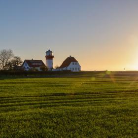 Solen står op på en dejlig forårsdag på Langeland og skinner over de grønner marker og fyrtårnet ved Hou,